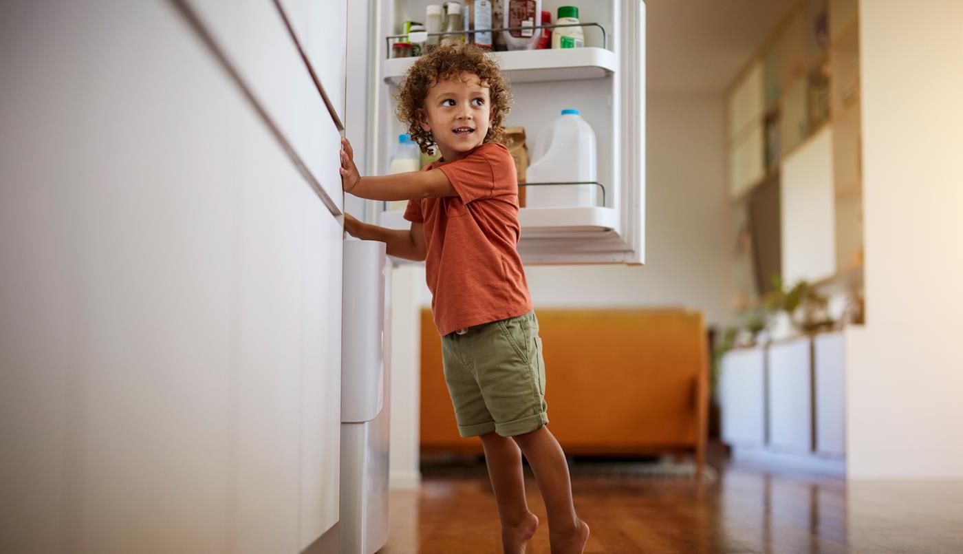 Child standing by fridge