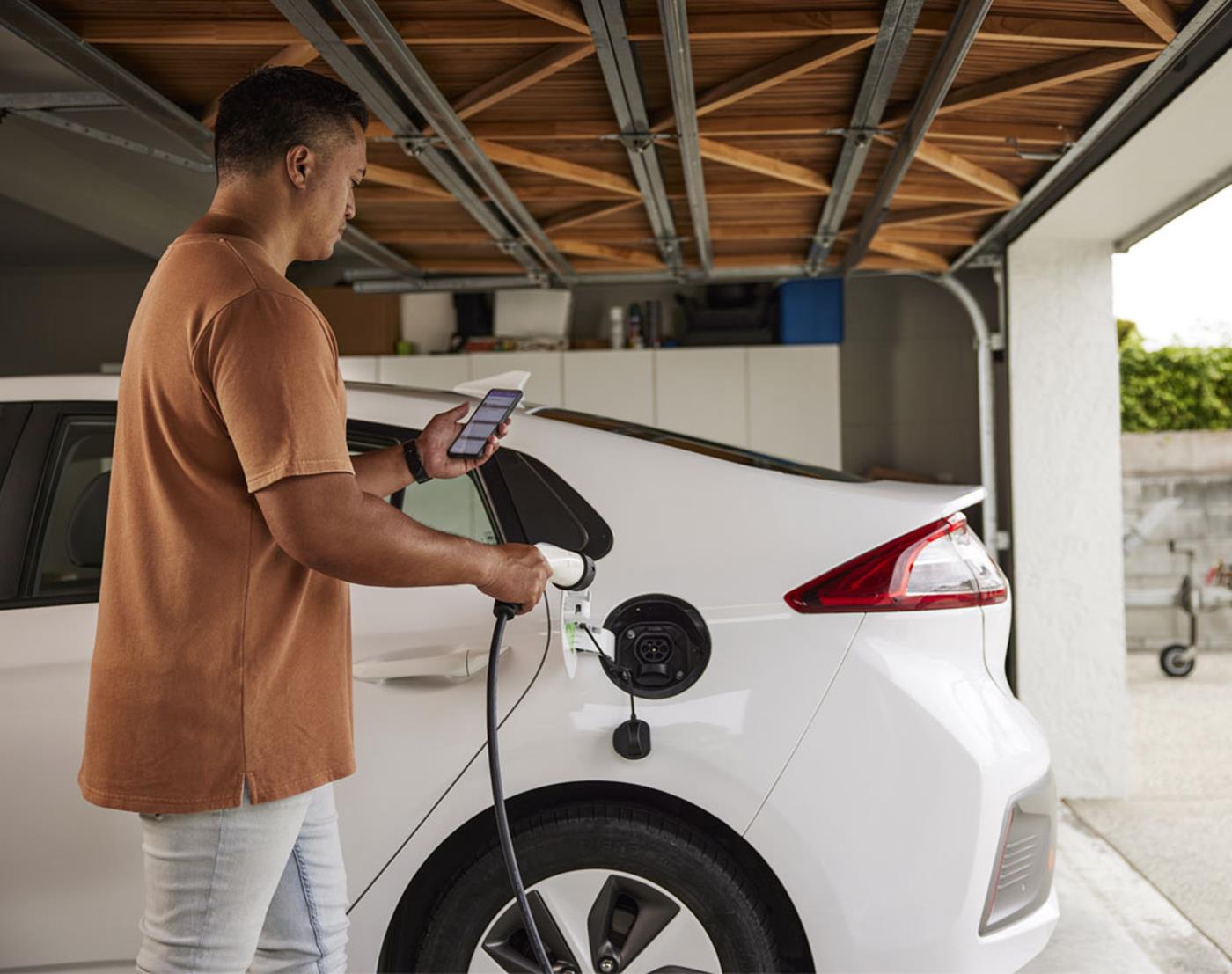 Man charging an electric vehicle in his garage