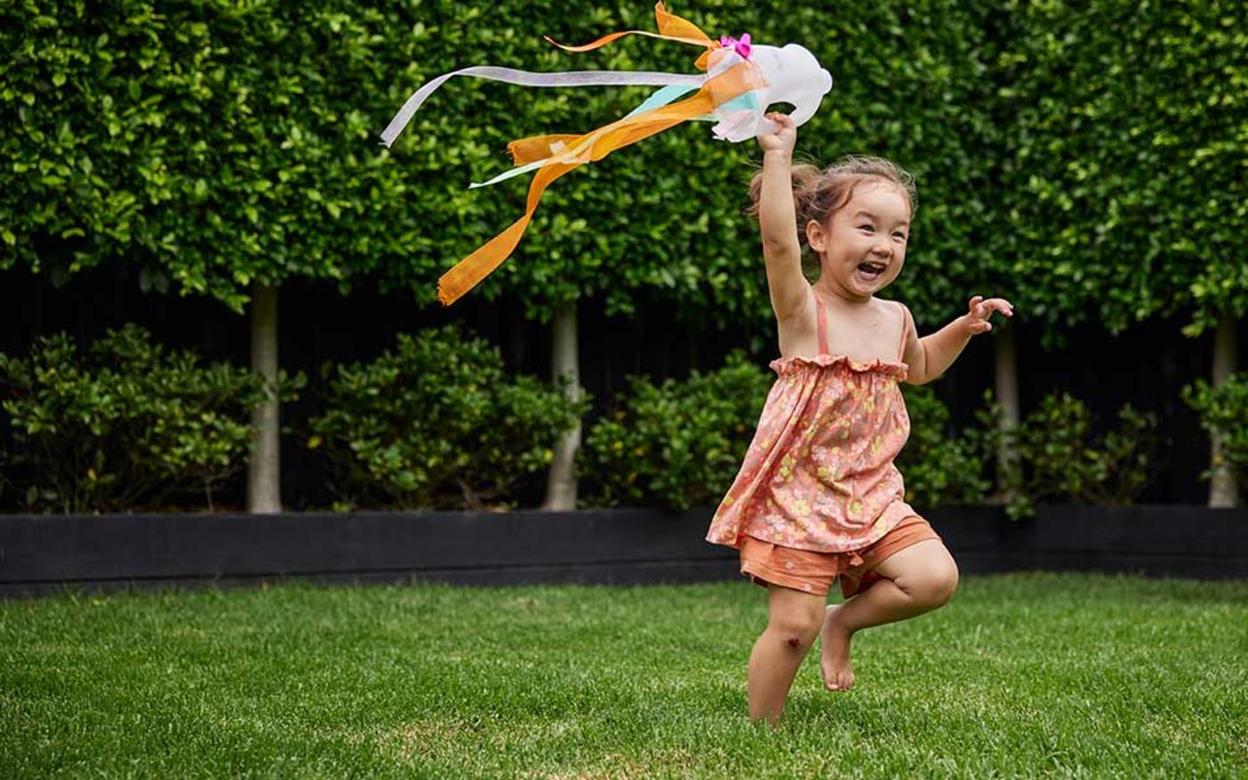 Little girl running with handheld kite