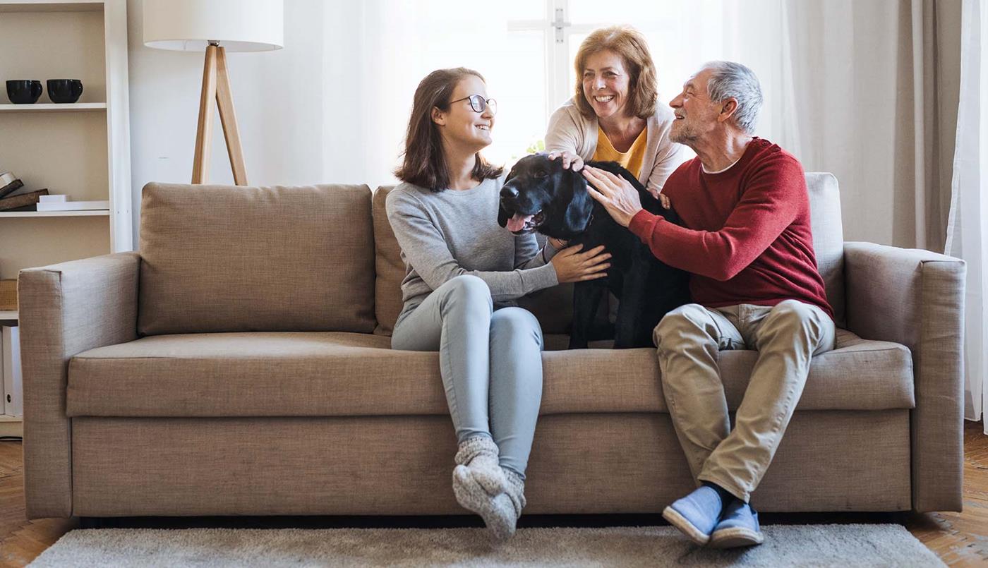Elderly couple on couch with teenager and dog