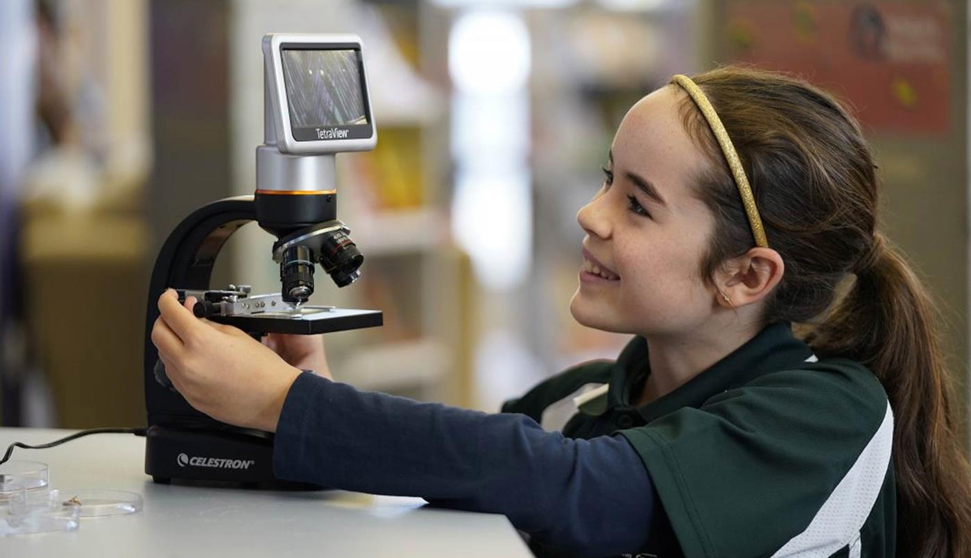 female student using microscope