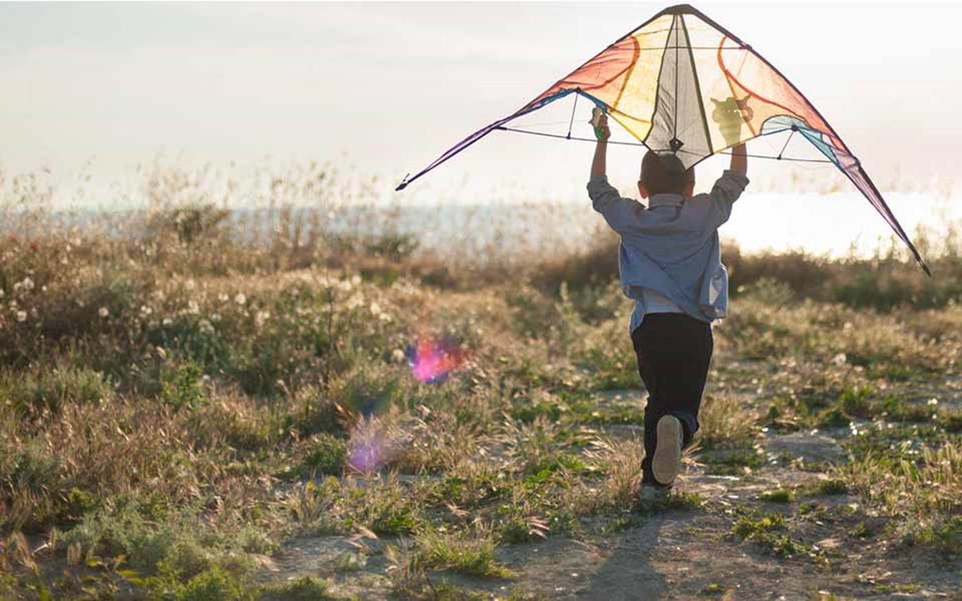 Boy flying colourful kite