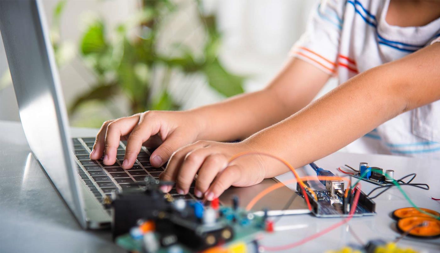 Child on laptop with stem equipment on desk